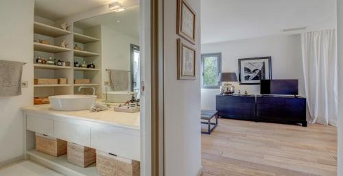 La salle de bains est pourvue d'un comptoir avec un lavabo et un miroir. dans l'établissement CYRIL Magnifique villa provençale, à Saint-Tropez