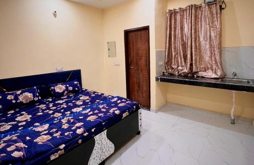een slaapkamer met een blauw bed en een raam bij Hotel Majestic INN in Phagwara