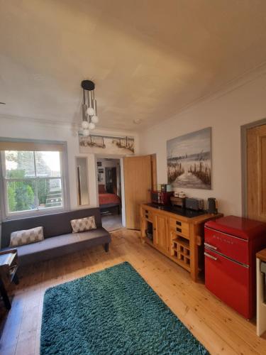 a living room with a couch and a table at Shore Thing - Just a stones throw from the beach in Sandgate