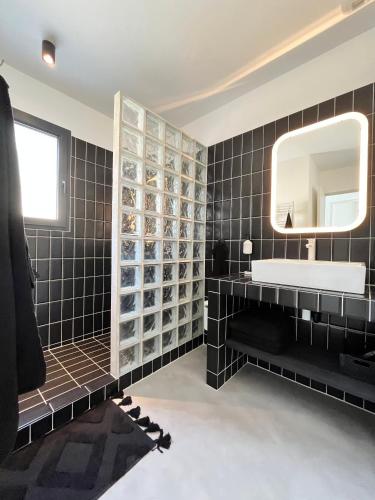 une salle de bain noire avec un lavabo et un miroir dans l'établissement Villa Casa Papey, à Draguignan