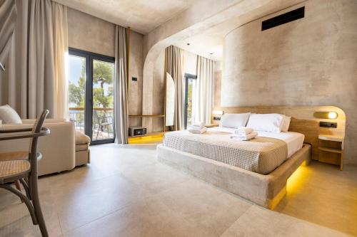 um quarto com uma cama grande e um sofá em Medusa Luxury Suites em Neos Marmaras
