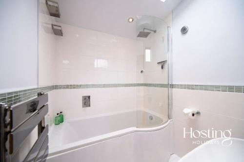 a white bathroom with a tub and a shower at Greys View Cottage in Henley on Thames