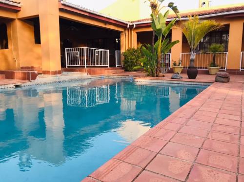 a swimming pool in front of a building at Inca Rose Guest House in Francistown