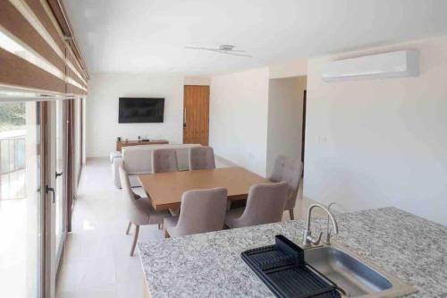 - une cuisine et une salle à manger avec une table et un évier dans l'établissement Departamento Puerta Al Mar, à Conchal