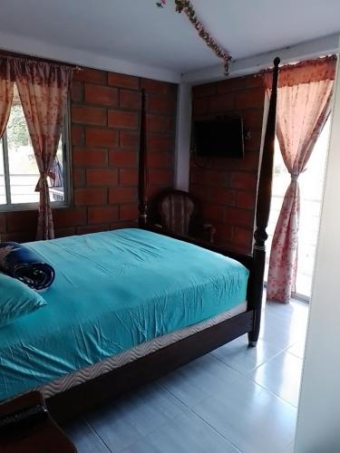 um quarto com uma cama com um edredão azul em La Clarita em San Rafael