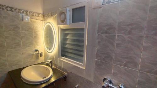 a bathroom with a toilet and a round window at Suite Room in Apartments in Bangalore