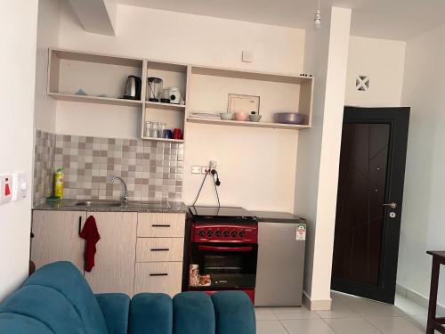 a kitchen with a blue couch and a stove at Gianna’s Stays in Mombasa