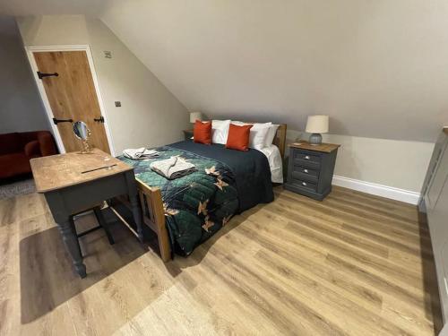 1 dormitorio con cama, escritorio y escritorio en Roseberry View Barn, Northallerton, en Northallerton