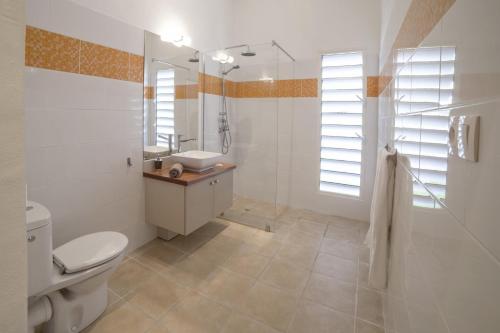 une salle de bains avec toilettes, lavabo et douche dans l'établissement Villas Coccoloba & Jacaranda, à Capesterre