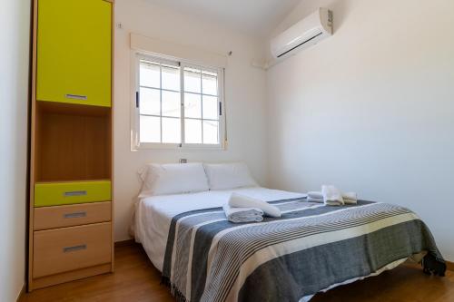 a small bedroom with a bed and a window at rentafive Piscina Urbanización Terraza in Santa Pola