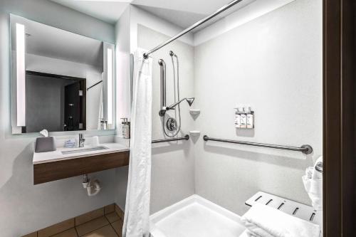 uma casa de banho com um chuveiro e um lavatório. em Holiday Inn Express Hotel & Suites Salina, an IHG Hotel em Salina