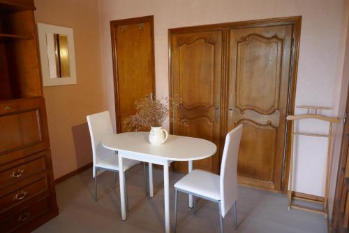 - une table et des chaises blanches dans la chambre dans l'établissement Chez Irène, à Félines-Minervois