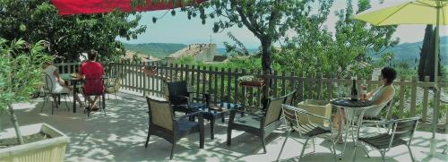 deux femmes assises à des tables et des chaises sur un patio dans l'établissement Chez Irène, à Félines-Minervois