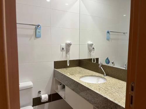 a bathroom with a sink and a phone at Nobile Hotel Araripina in Araripina