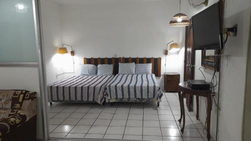 1 dormitorio con 1 cama y TV en Hotel Luigi en San Salvador
