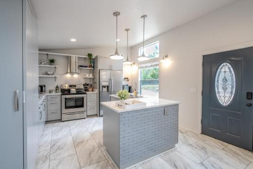 a kitchen with white cabinets and a blue door at Serene Hill Country Home w/ Romantic Garden Escape in Driftwood