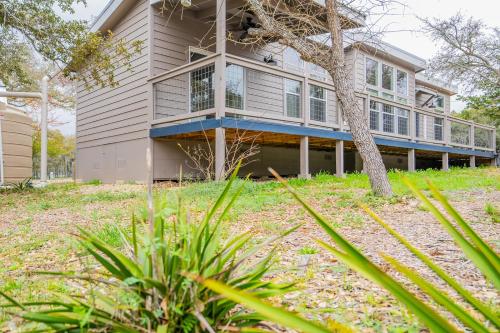 a house with a porch and a tree at Serene Hill Country Home w/ Romantic Garden Escape in Driftwood