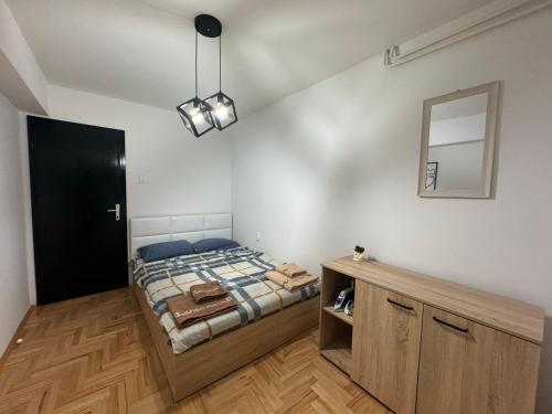 Schlafzimmer mit einem Bett und einem Wandspiegel in der Unterkunft A Cozy Retreat in Skopje