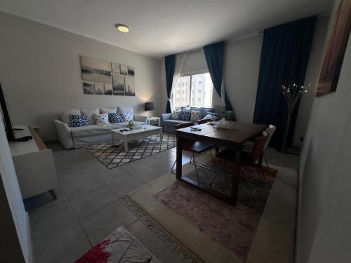 شقق فخامة الشروق في King Abdullah Economic City: غرفة معيشة مع طاولة وأريكة