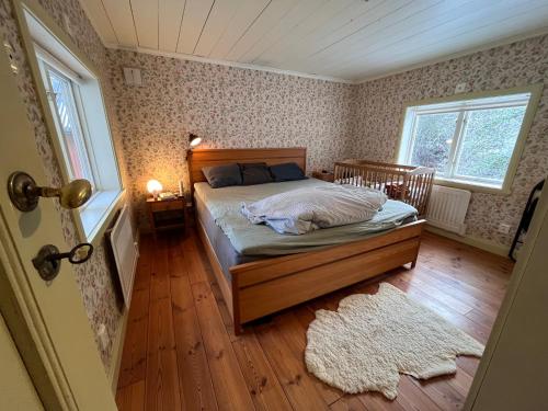 - une chambre avec un lit, une fenêtre et un tapis dans l'établissement Charming Countryside Cottage, à Varekil