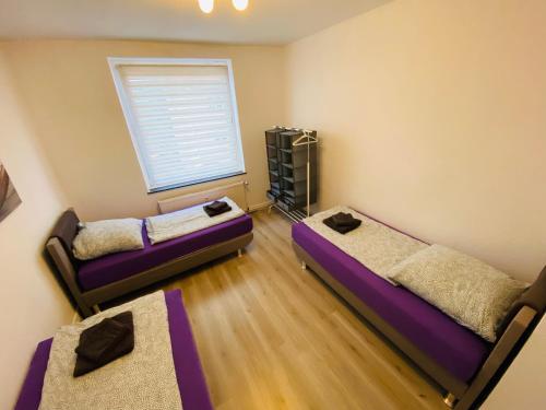 Duas camas num quarto com uma janela em Beautiful Apartment I 4 Beds I Fast WiFi I Kitchen em Bielefeld