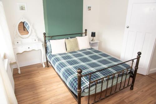 クリーソープスにあるLily's Placeのベッドルーム1室(ベッド1台、プライド毛布、鏡付)