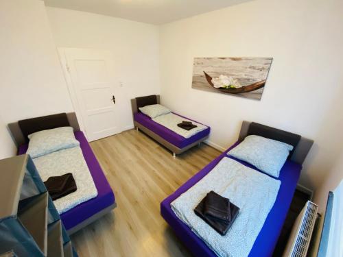Habitación con 3 camas y una pintura en la pared. en Beautiful Apartment I 4 Beds I Fast WiFi I Kitchen en Bielefeld