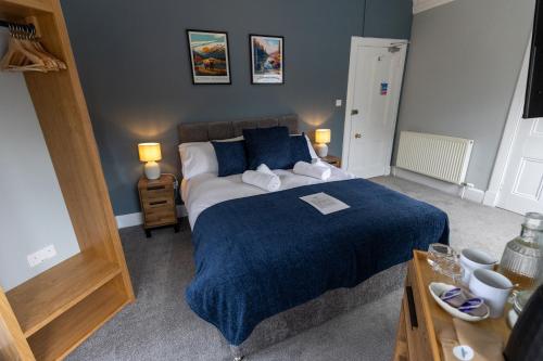 um quarto com uma cama grande e um cobertor azul em The Crossing Bed and Breakfast em Kingussie