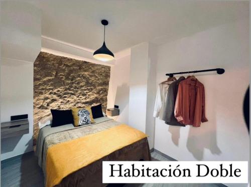 ein Schlafzimmer mit einem Bett und einem aptiondb-Schild an der Wand in der Unterkunft Cueva Luxe Las Calcetas in Setenil de las Bodegas