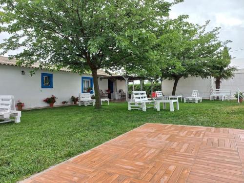 un patio con mesas y sillas blancas y un árbol en Villalegría. Casa de campo cercana a Puy du Fou, en Totanés