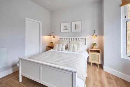 a white bedroom with a white bed and two windows at Host & Stay - Poplar Villas in Ramsgate