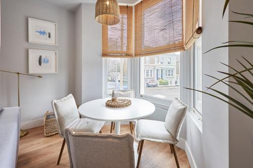 uma sala de jantar com uma mesa e cadeiras e uma janela em Host & Stay - Poplar Villas em Ramsgate