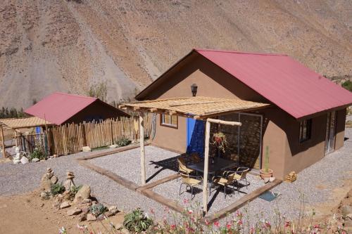 a small house with a red roof in the desert at Cumbres de Alcohuaz in Alcoguaz