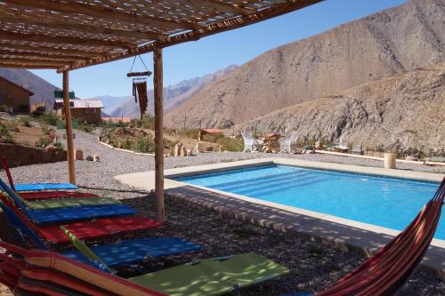 a swimming pool with two chairs and a swimming poolvisorvisor at Cumbres de Alcohuaz in Alcoguaz