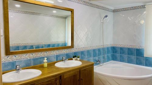 a bathroom with two sinks and a tub and a mirror at LA CASITA DE MANOLI in Chillarón de Cuenca