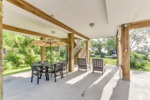 a patio with a table and chairs and an umbrella at Seabrook Getaway with Balconies and Bay Views! in Seabrook