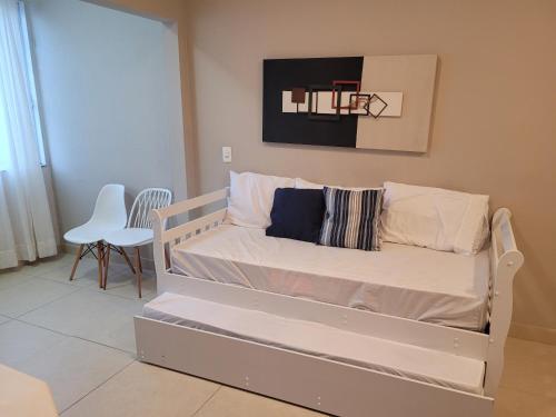 Cama blanca en una habitación con baloncesto en Apartamento em Tijucas próximo a praias, en Tijucas