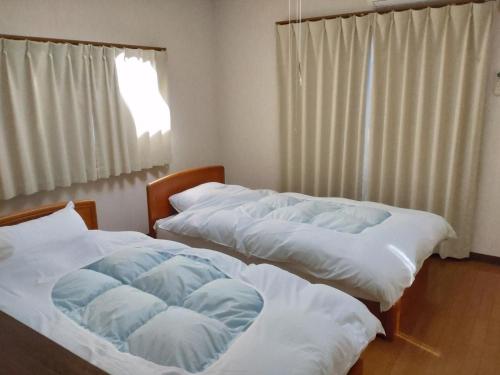 dwa łóżka w pokoju z oknem w obiekcie Ten Ten Go Shibu Kawa - Vacation STAY 41956v w mieście Ono