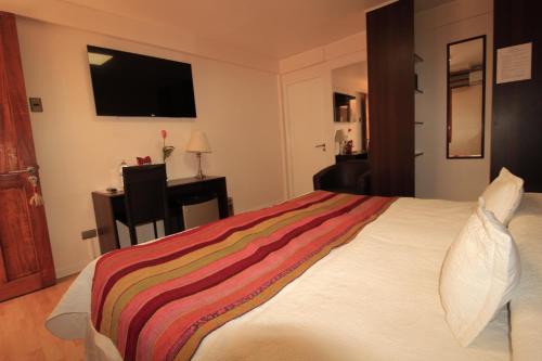 Un dormitorio con una cama con una manta de colores. en Atankalama, en Calama