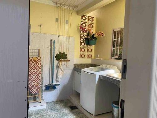 y baño con lavabo y lavadora. en Apartamento Encantador C en Montes Claros