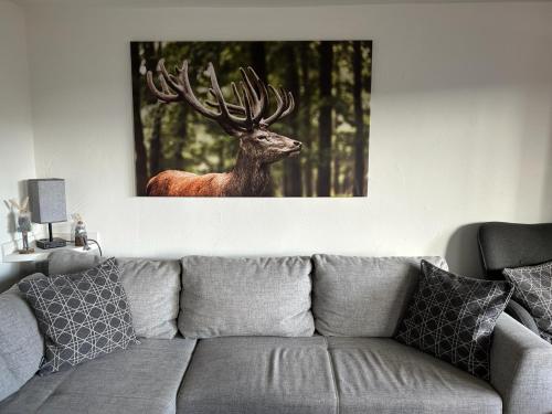 a picture of a deer on the wall above a couch at Bungalow Schwarzatalblick in Bad Blankenburg Ortsteil Böhlscheiben in Bad Blankenburg