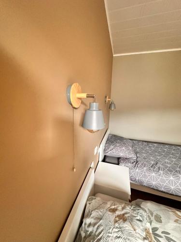 a small room with a bed and a lamp at Le Coin Rocheux in La Roche-en-Ardenne
