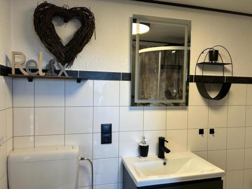 a bathroom with a toilet and a sink and a mirror at Bungalow Schwarzatalblick in Bad Blankenburg Ortsteil Böhlscheiben in Bad Blankenburg