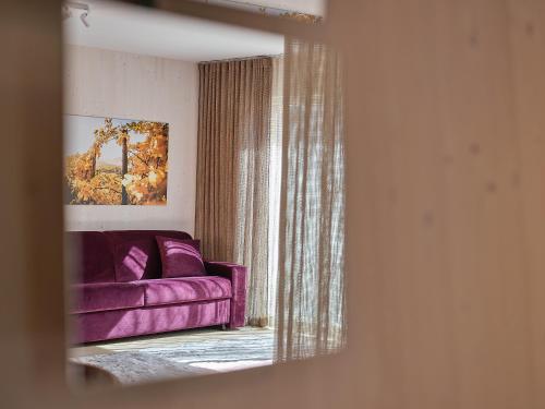 a purple couch in a living room with a window at Haus Fünf mit 2 Apartments und Studio-Loft mit Terrasse in Melk