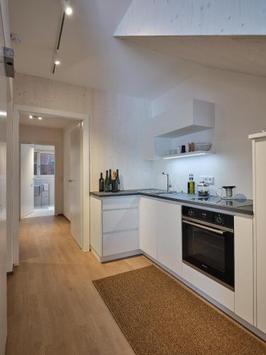 a kitchen with white cabinets and a black oven at Haus Fünf mit 2 Apartments und Studio-Loft mit Terrasse in Melk