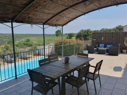 un patio avec une table et des chaises et une piscine dans l'établissement Maison de vacances avec piscine à 5mn d'Uzes, à Saint-Maximin