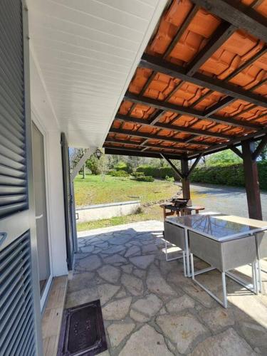 d'une terrasse avec une table et un toit en bois. dans l'établissement Maison de campagne, au calme., à Carlux