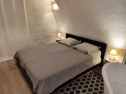 a bedroom with a bed with two lamps and a couch at Le logis du Barry in Montpeyroux