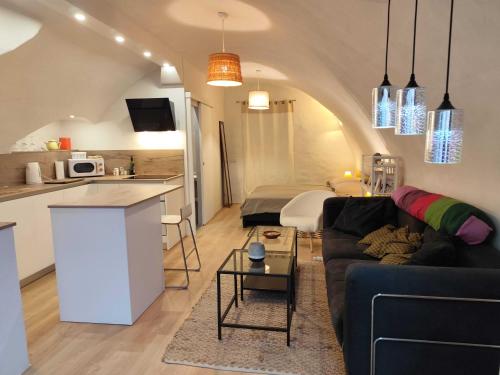 sala de estar con sofá y cocina en Le logis du Barry en Montpeyroux