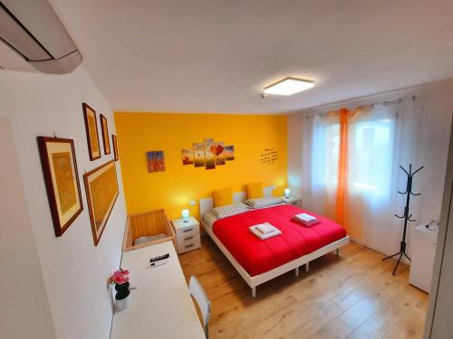 a bedroom with a red bed and a yellow wall at New Bedrooms Mamma Gigetta in Noventa di Piave